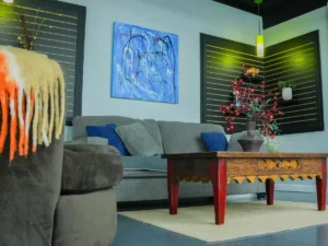 Casual client meeting area at MicroOffice Solutions Casper Wyoming with grey sofa, vintage coffee table, blue cushions and abstract wall art