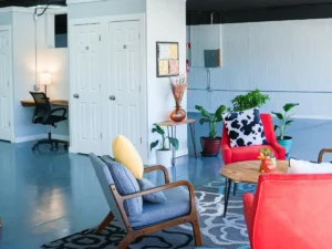 MicroOffice Solutions Casper Wyoming client meeting area with colorful mid-century chairs, plants, and numbered private micro-office suite doors in background