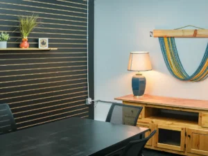 MicroOffice Solutions conference room in Casper Wyoming with black meeting table, mesh chairs, slatwall accent wall with plants and decor, and wooden credenza