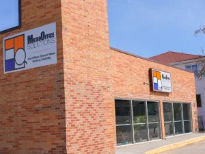 MicroOffice Solutions business center exterior at 2240 E 12th Street Casper Wyoming showing brick building with two branded signs reading Real Offices Beyond Virtual Banking Credibility
