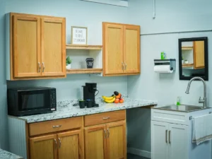MicroOffice Solutions Casper Wyoming tenant kitchen with Keurig coffee maker, microwave, countertop, upper cabinets, sink and fresh fruit