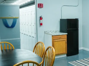 MicroOffice Solutions Casper Wyoming kitchen and break room area with dining table, wooden chairs, refrigerator and countertop with row of micro-office suite doors visible in background